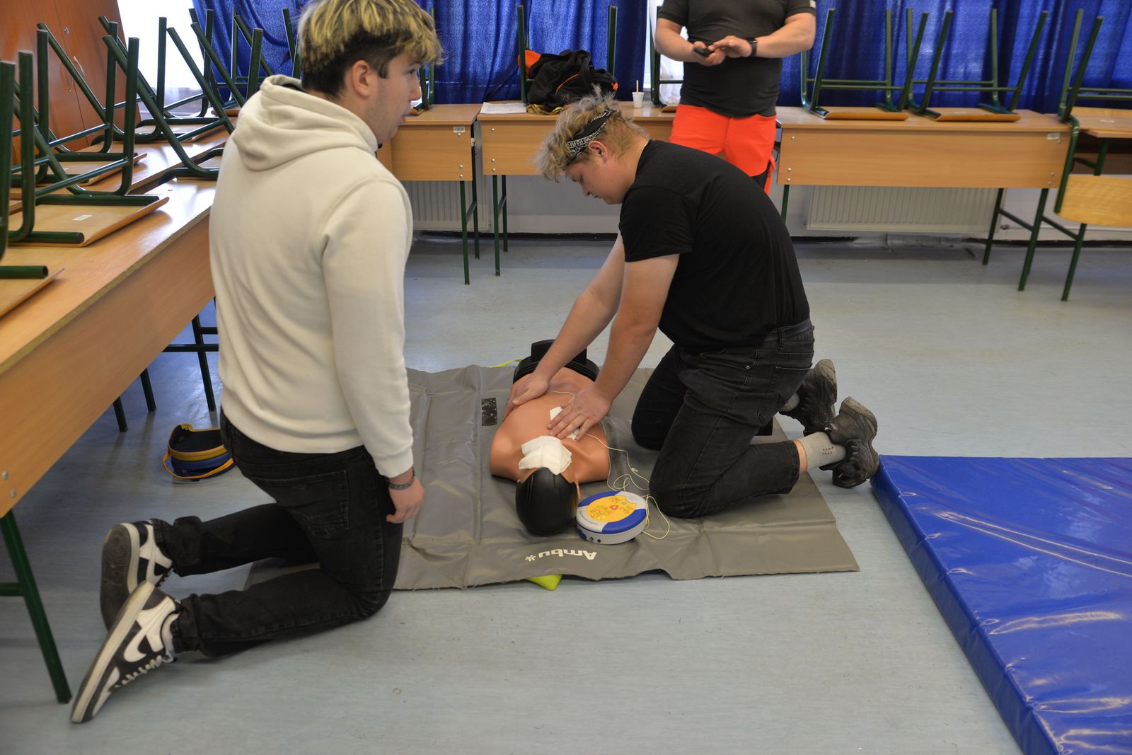A group taking part in CPR training in a classroom
